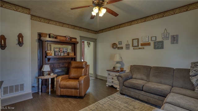 living room with visible vents, baseboards, ceiling fan, wood finished floors, and a textured ceiling