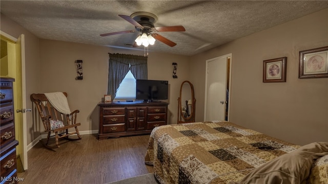 bedroom featuring ceiling fan, dark wood-style floors, baseboards, and a textured ceiling