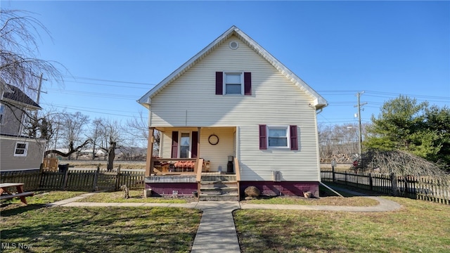 bungalow with a porch, a front lawn, and fence