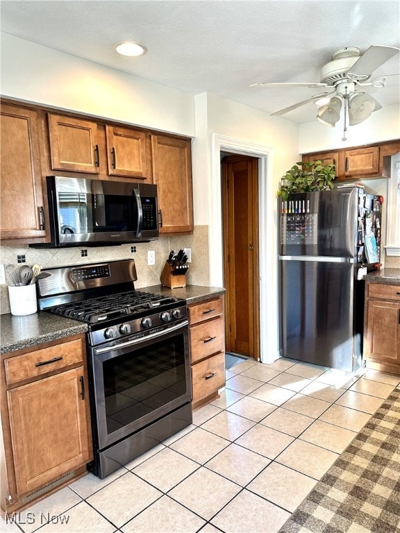 kitchen with decorative backsplash, appliances with stainless steel finishes, ceiling fan, and brown cabinetry