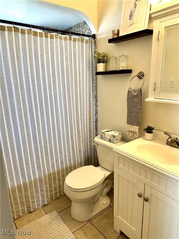 bathroom with tile patterned floors, curtained shower, toilet, and vanity