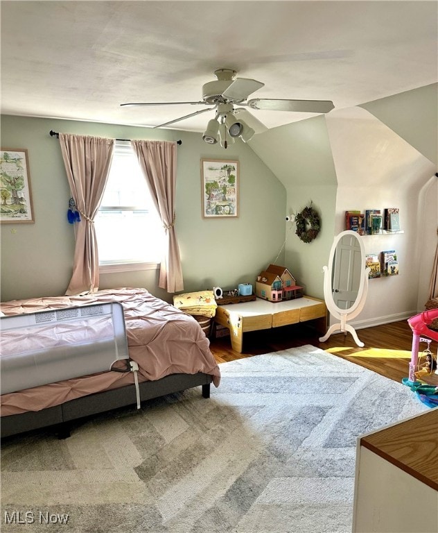 bedroom featuring ceiling fan, wood finished floors, and vaulted ceiling