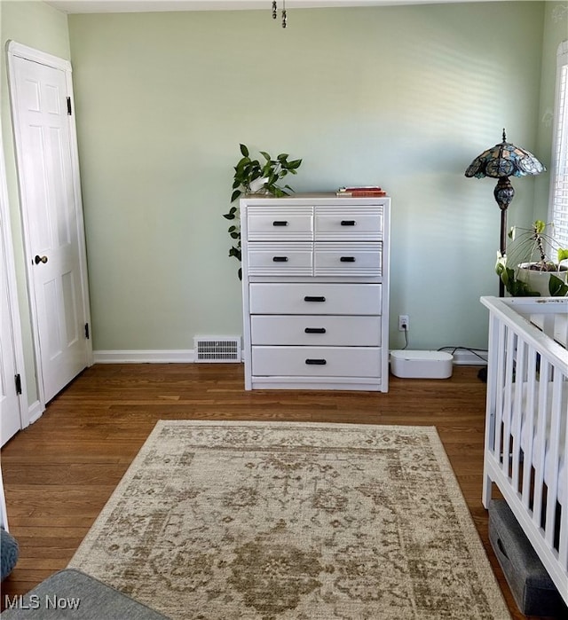 bedroom featuring dark wood-style floors, visible vents, and baseboards