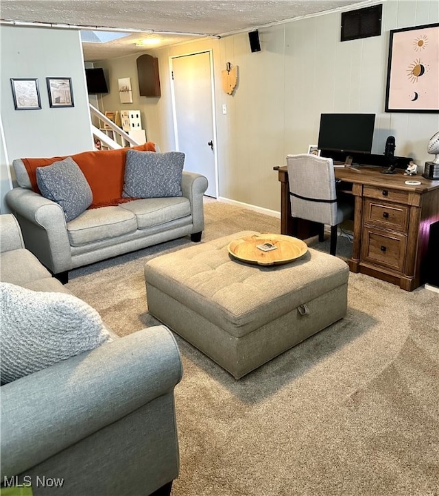 carpeted living room featuring stairway and a textured ceiling