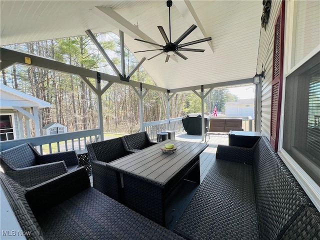 wooden terrace featuring outdoor lounge area, an outdoor structure, a storage unit, and ceiling fan