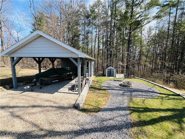 view of yard with an outdoor fire pit, a storage unit, gravel driveway, and an outdoor structure