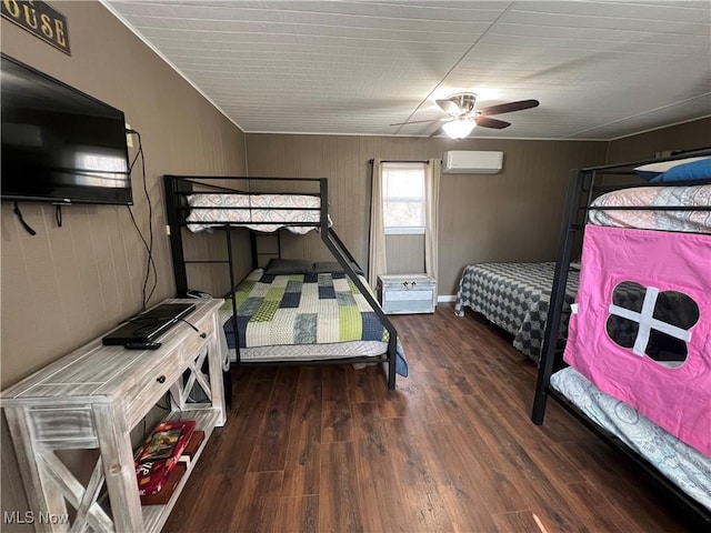 bedroom with ceiling fan, wood finished floors, and a wall unit AC