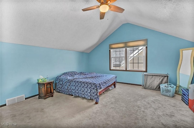 bedroom with visible vents, vaulted ceiling, carpet flooring, a textured ceiling, and a ceiling fan