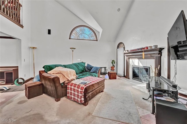 carpeted living area with high vaulted ceiling and a fireplace