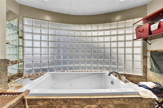 full bath with a textured ceiling and a tub with jets