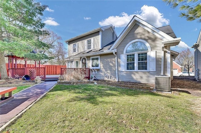 rear view of house with central AC unit, a lawn, a deck, and fence