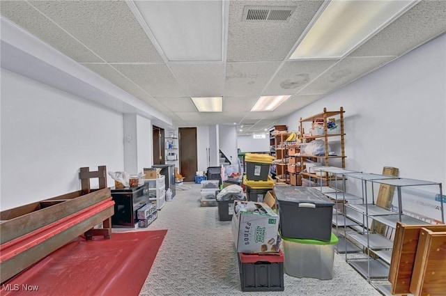 miscellaneous room featuring stairway, carpet flooring, a paneled ceiling, and visible vents