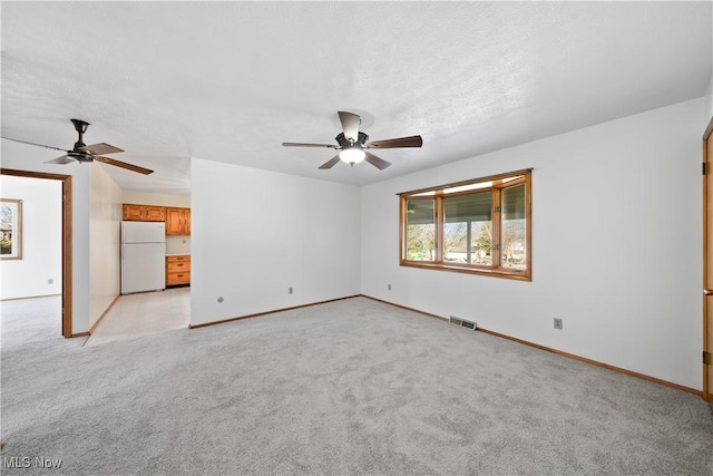 unfurnished living room with light carpet, baseboards, visible vents, and ceiling fan