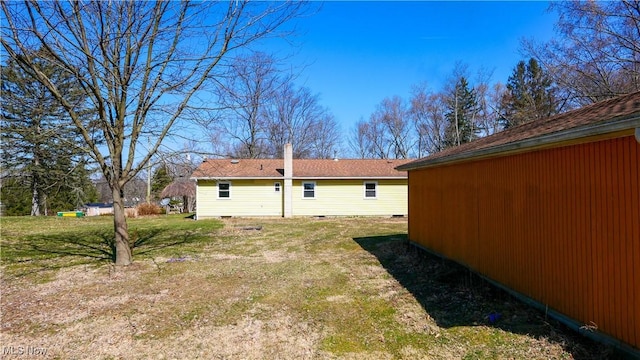 rear view of house with crawl space and a lawn