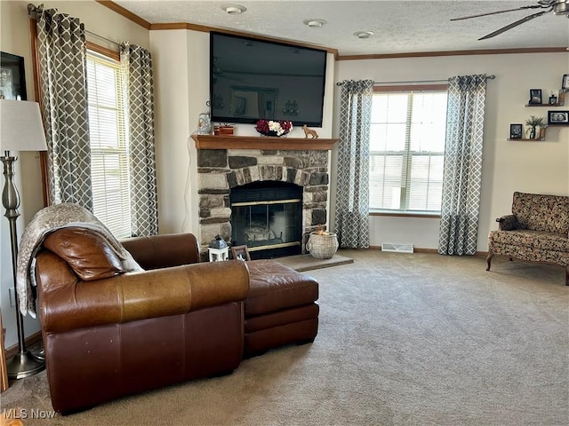 carpeted living room featuring plenty of natural light, a textured ceiling, a ceiling fan, and ornamental molding