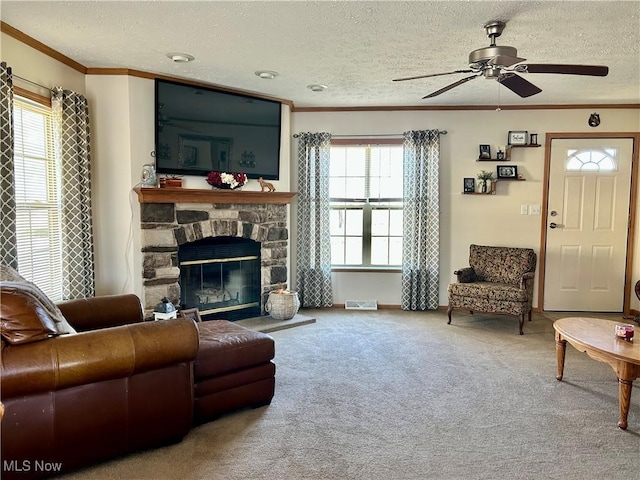 carpeted living area with a ceiling fan, visible vents, a wealth of natural light, and ornamental molding