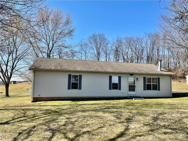 view of front of home featuring a front lawn and a shingled roof