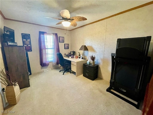 office space with visible vents, crown molding, carpet, a textured ceiling, and a ceiling fan