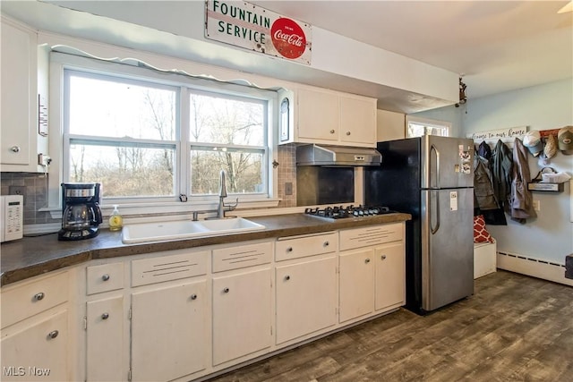 kitchen with gas stovetop, freestanding refrigerator, a sink, under cabinet range hood, and a baseboard heating unit