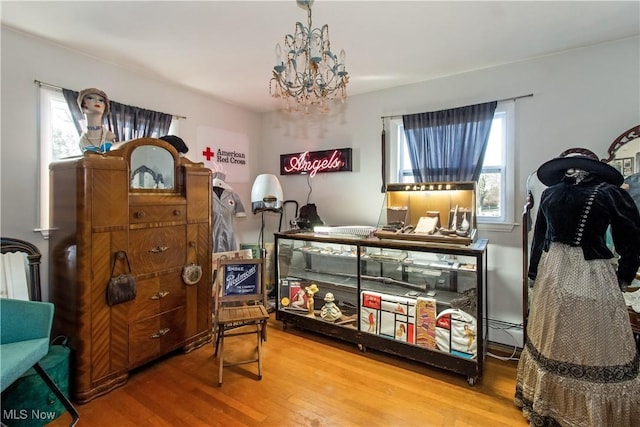 bedroom featuring a notable chandelier, wood finished floors, and a baseboard radiator