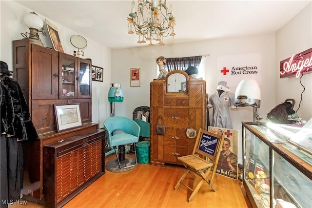 sitting room with a notable chandelier and light wood-style floors