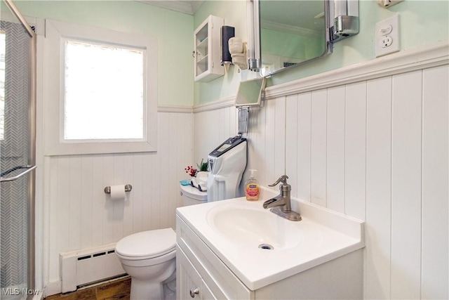 bathroom with toilet, a baseboard heating unit, wainscoting, a shower, and vanity