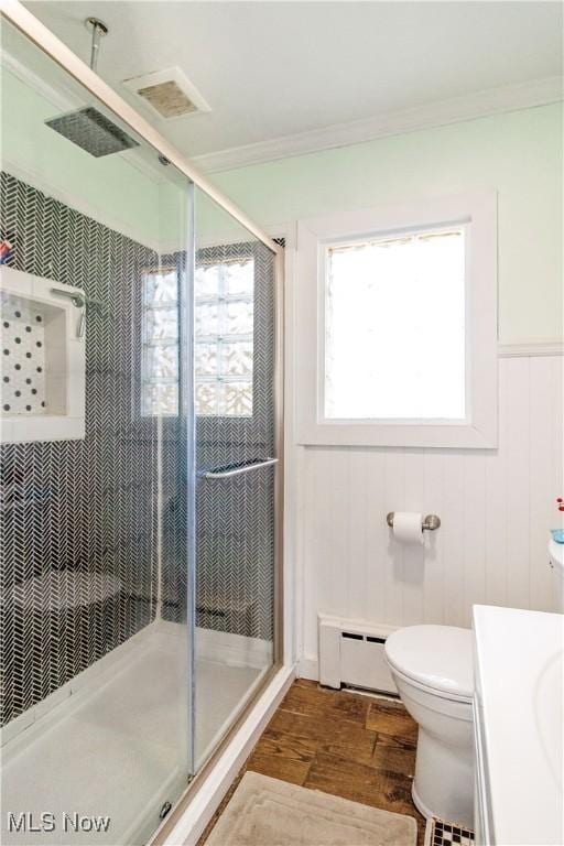 bathroom featuring wood finished floors, visible vents, a stall shower, ornamental molding, and a baseboard heating unit