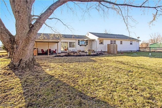 rear view of property with a patio, a lawn, and fence