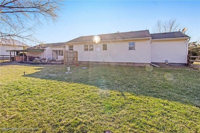 back of house with a lawn and fence