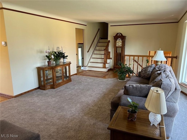 carpeted living room featuring stairway, crown molding, and baseboards