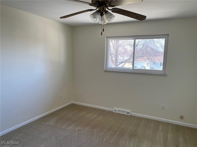 empty room featuring a ceiling fan, visible vents, carpet floors, and baseboards