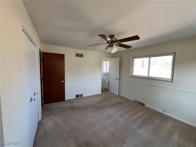 unfurnished room with visible vents, baseboards, a ceiling fan, and carpet floors