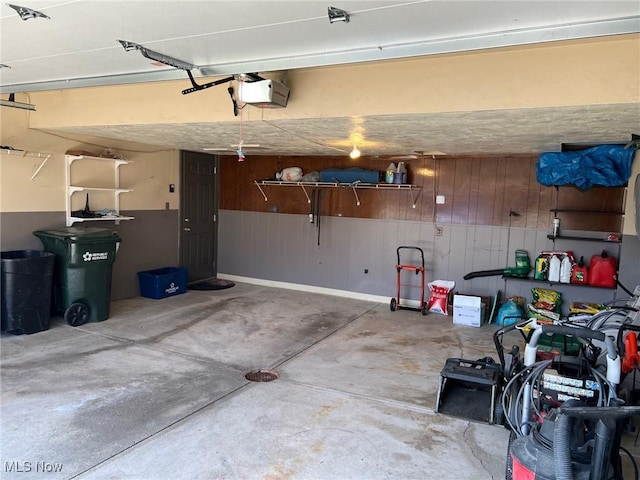 garage featuring a garage door opener and wood walls