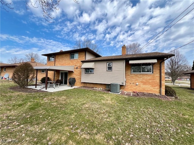 back of house with brick siding, central AC unit, a lawn, a chimney, and a patio area