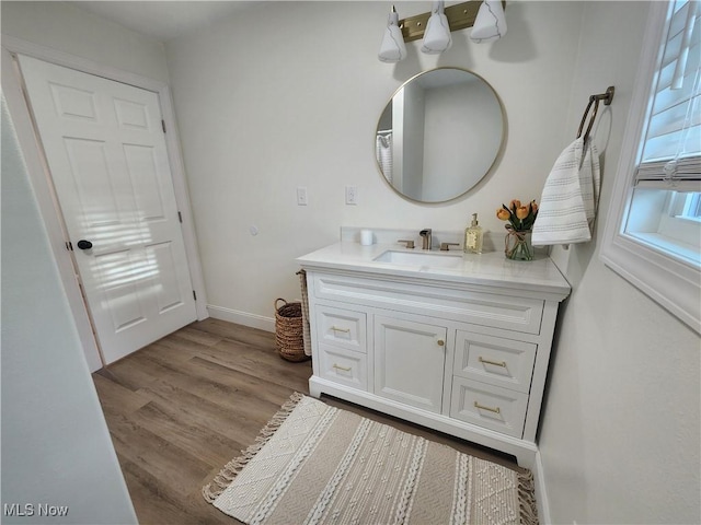 bathroom with vanity, baseboards, and wood finished floors