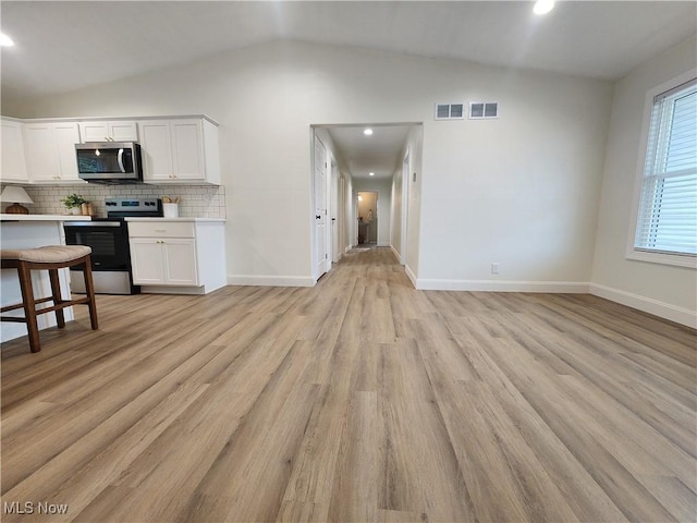 kitchen with visible vents, tasteful backsplash, appliances with stainless steel finishes, light countertops, and vaulted ceiling