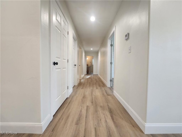 hall featuring recessed lighting, baseboards, and light wood-style flooring