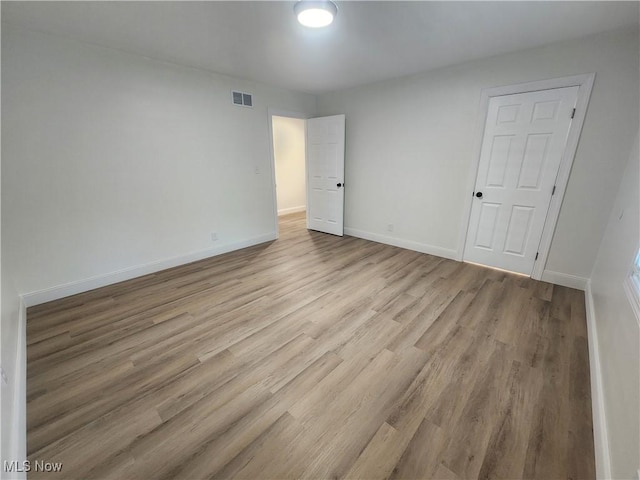 unfurnished bedroom with visible vents, baseboards, and light wood finished floors