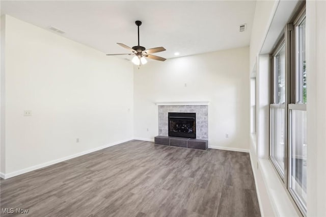 unfurnished living room with a ceiling fan, wood finished floors, visible vents, and baseboards