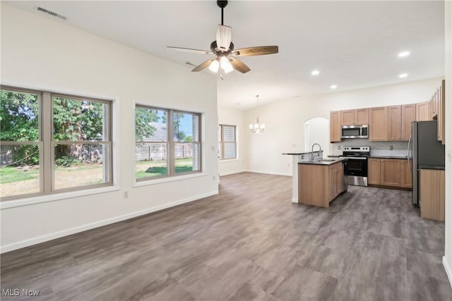 kitchen with visible vents, ceiling fan with notable chandelier, backsplash, open floor plan, and stainless steel appliances