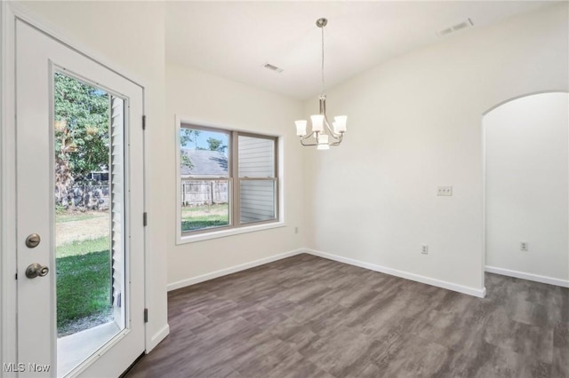 unfurnished dining area with a notable chandelier, dark wood-style floors, visible vents, and baseboards