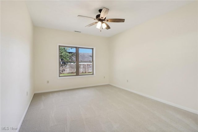 spare room featuring visible vents, baseboards, light colored carpet, and a ceiling fan