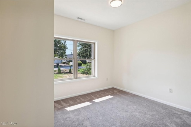 empty room with visible vents, baseboards, and carpet