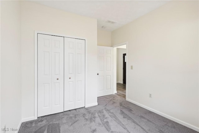 unfurnished bedroom featuring a closet, visible vents, baseboards, and carpet