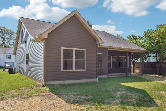 back of house featuring a yard, central AC, and a shingled roof