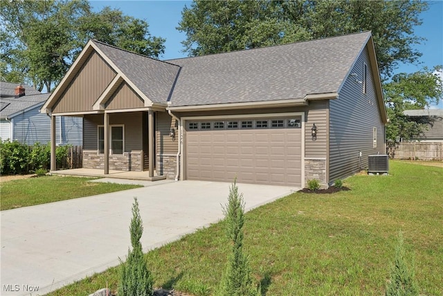 craftsman-style house featuring driveway, a front lawn, stone siding, a porch, and an attached garage