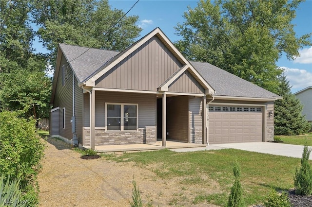 craftsman house featuring a front yard, concrete driveway, a garage, stone siding, and board and batten siding