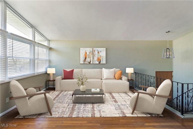 living room with baseboards, an inviting chandelier, and wood finished floors