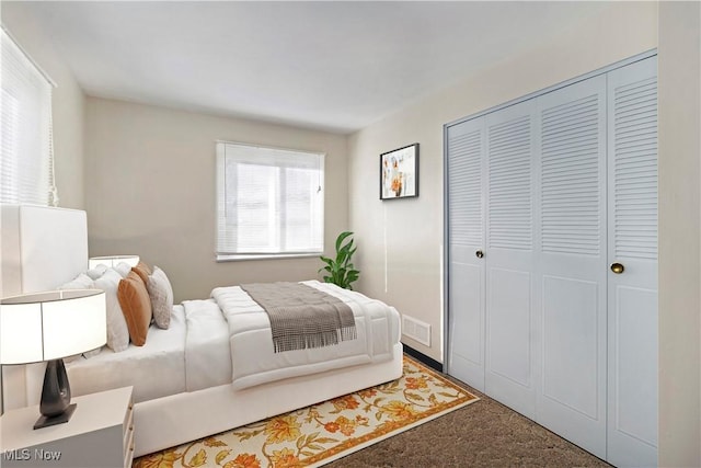 carpeted bedroom featuring visible vents and a closet