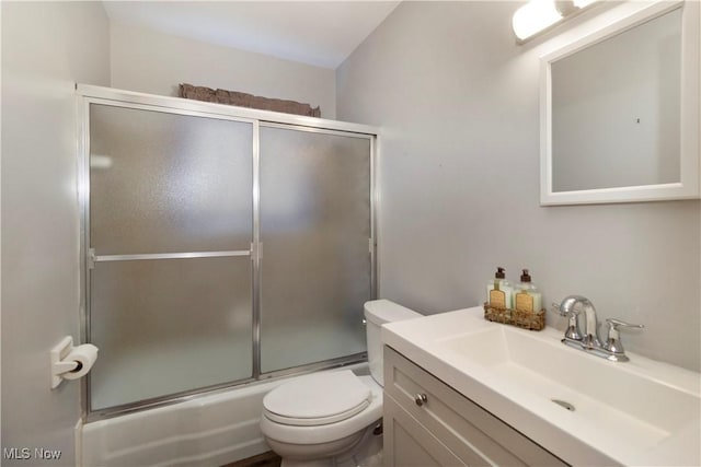 full bath with toilet, vanity, and bath / shower combo with glass door